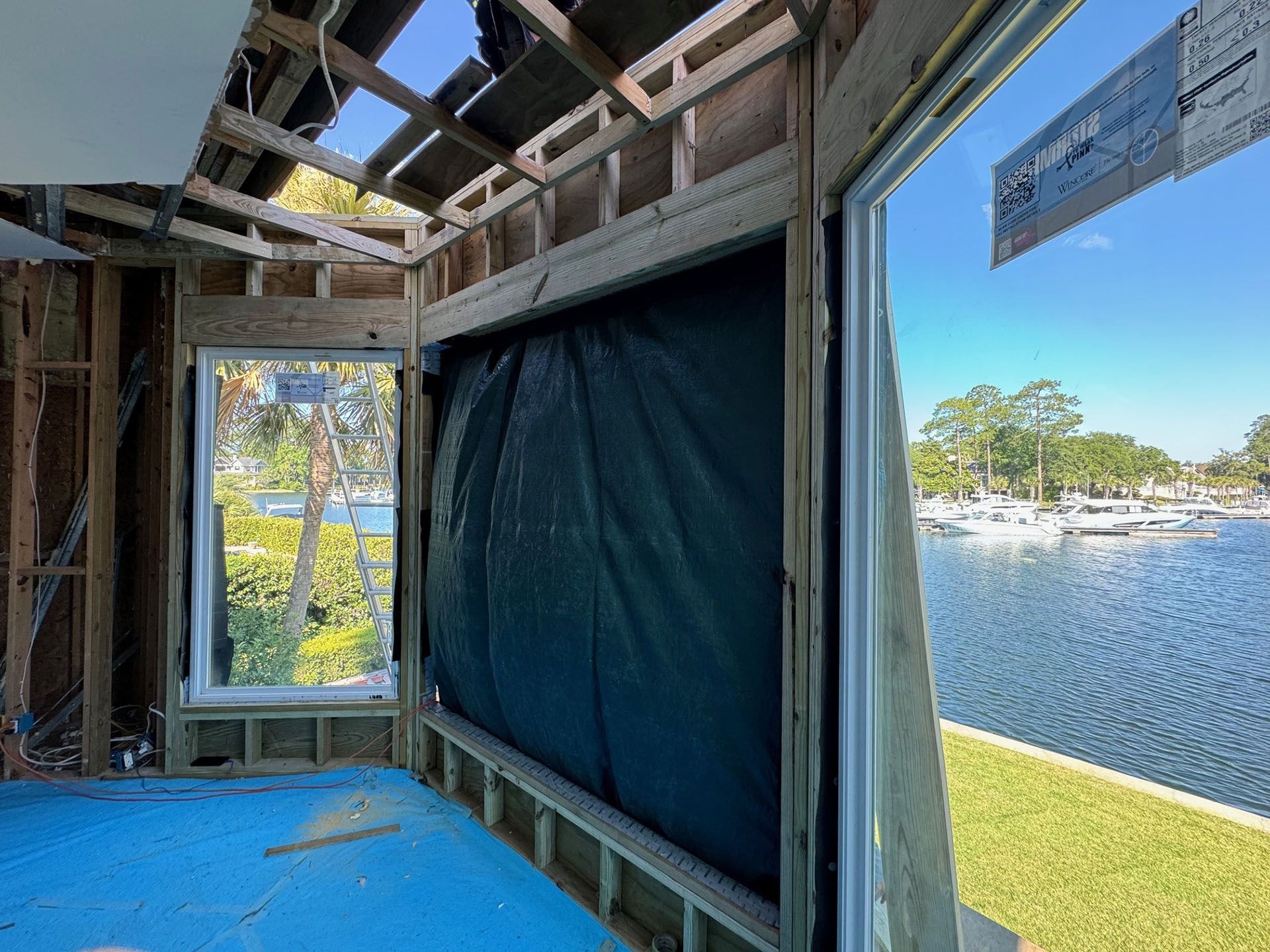 Termite Damage - Interior construction with framed windows overlooking a waterfront with boats.