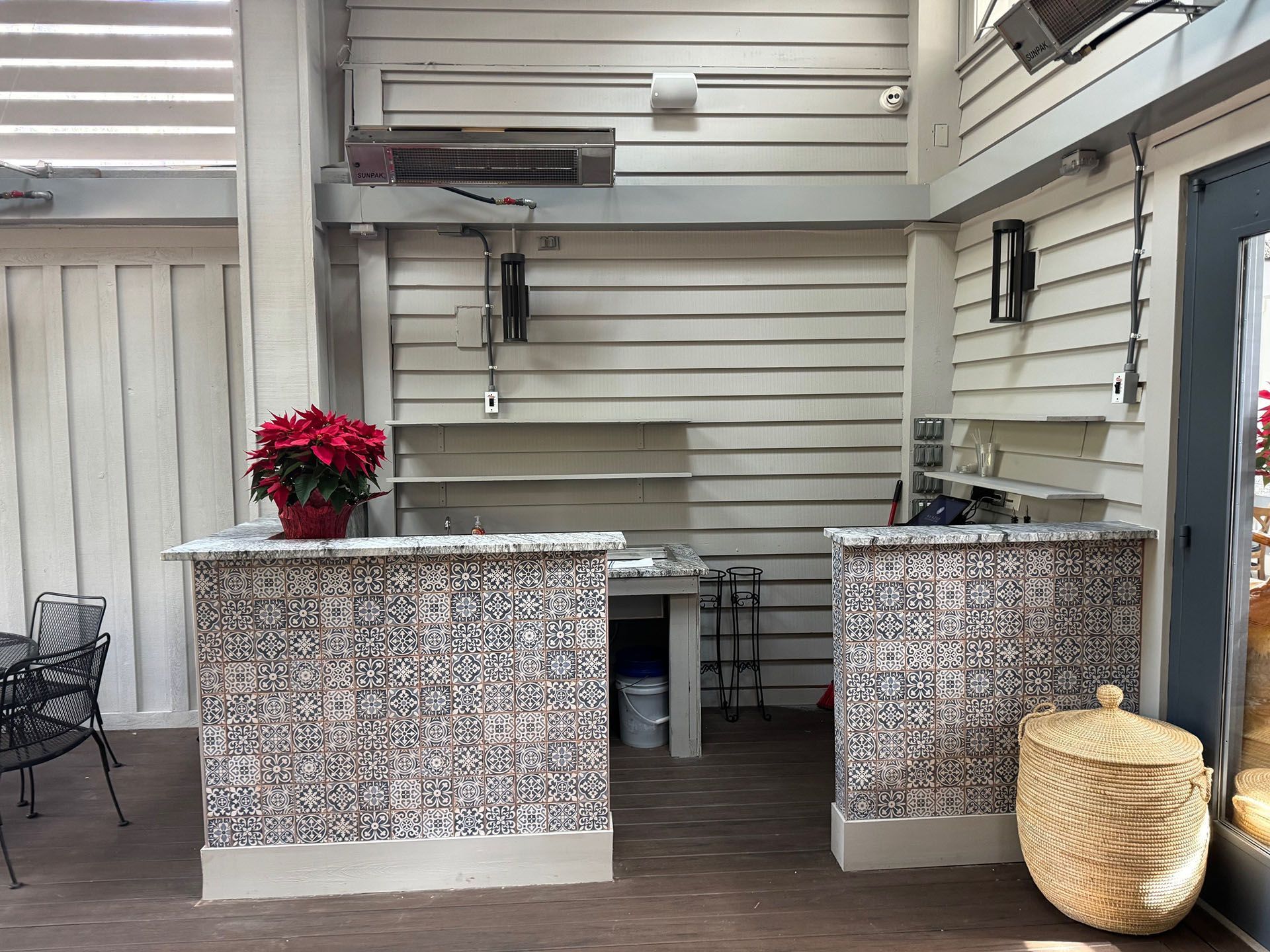 Commercial restaurant remodel and expansion  - Nunzios/After: Outdoor bar with two counters, red poinsettia, and a woven basket.