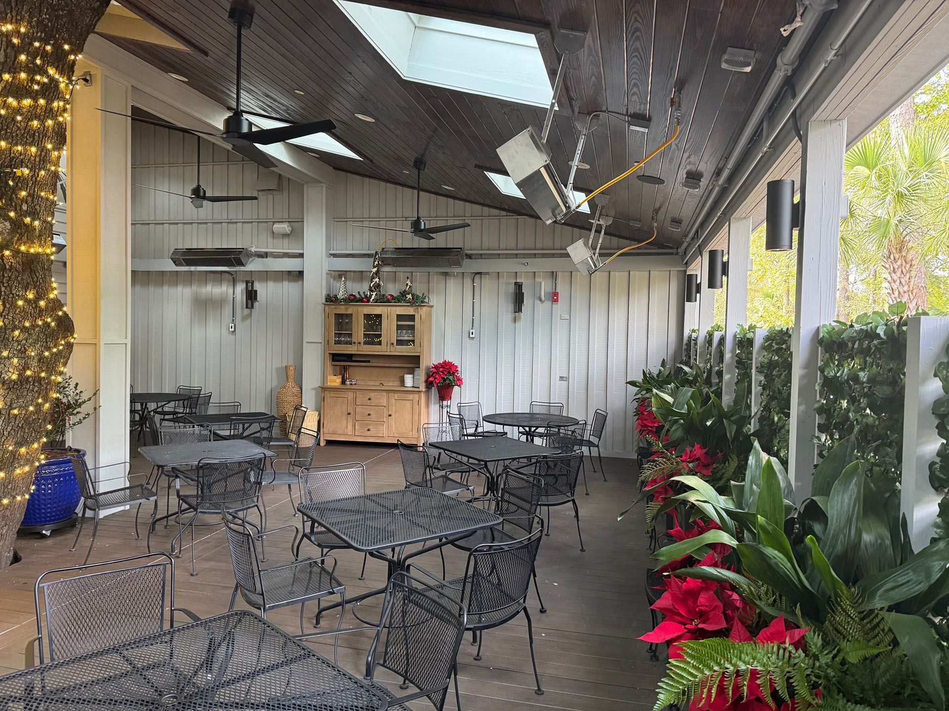 Commercial restaurant remodel and expansion  - Nunzios/After: Outdoor patio with tables and chairs, under a covered area. Plants and decorations are visible.