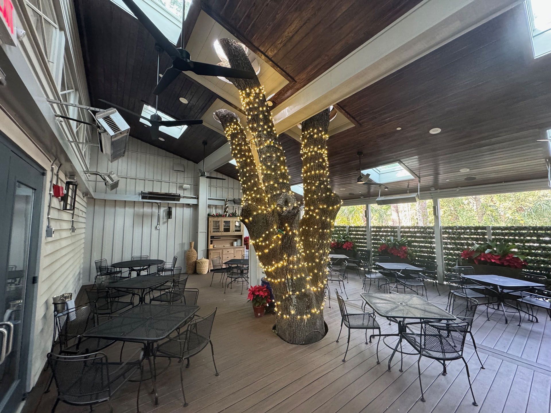 Commercial restaurant remodel and expansion  - Nunzios/After: Outdoor restaurant seating area with tables and chairs, illuminated tree, and a wooden deck.