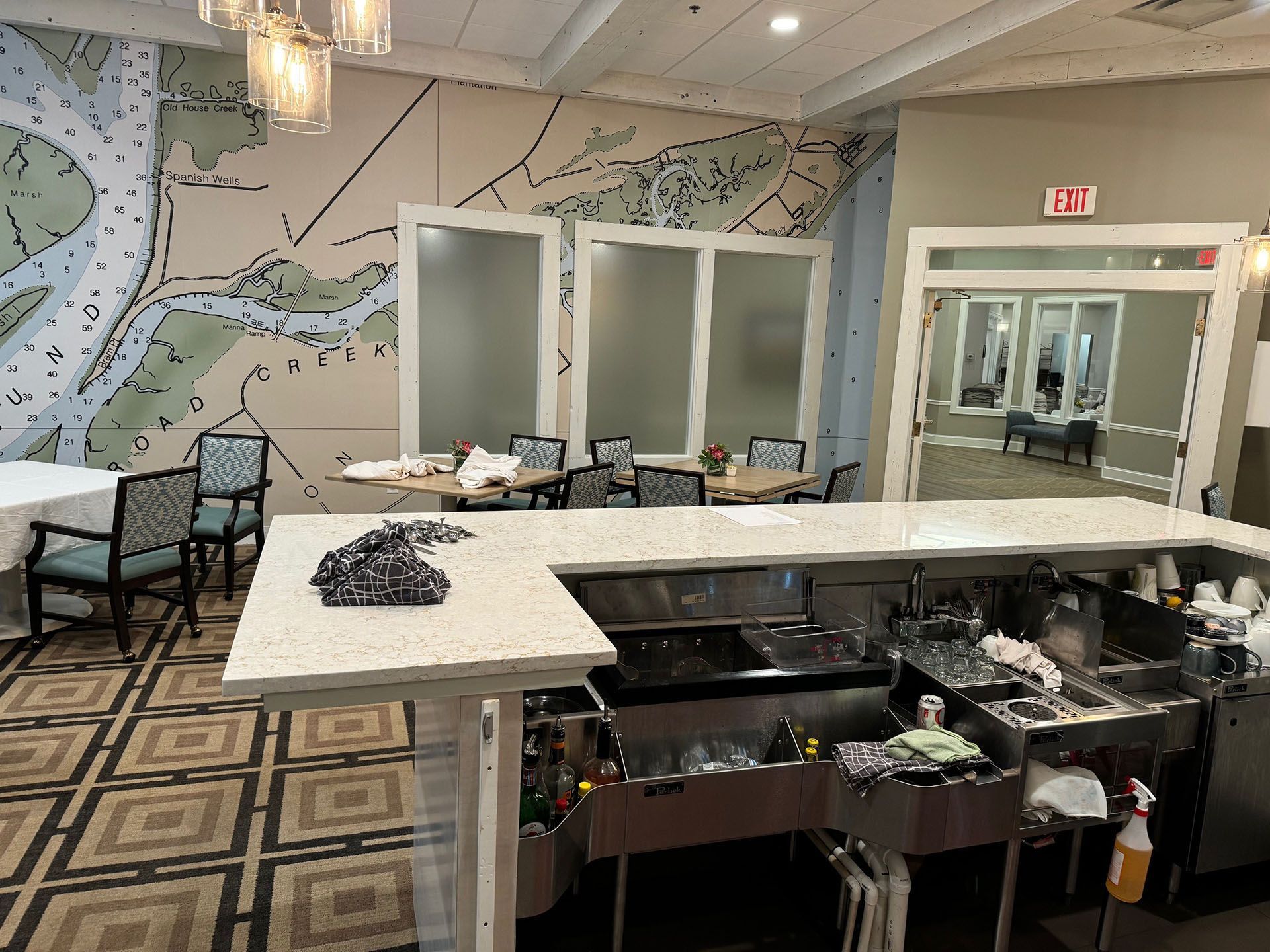 Commercial restaurant remodel and expansion - Tidepoint/After: Restaurant interior with a bar, tables, and a map mural on the wall.