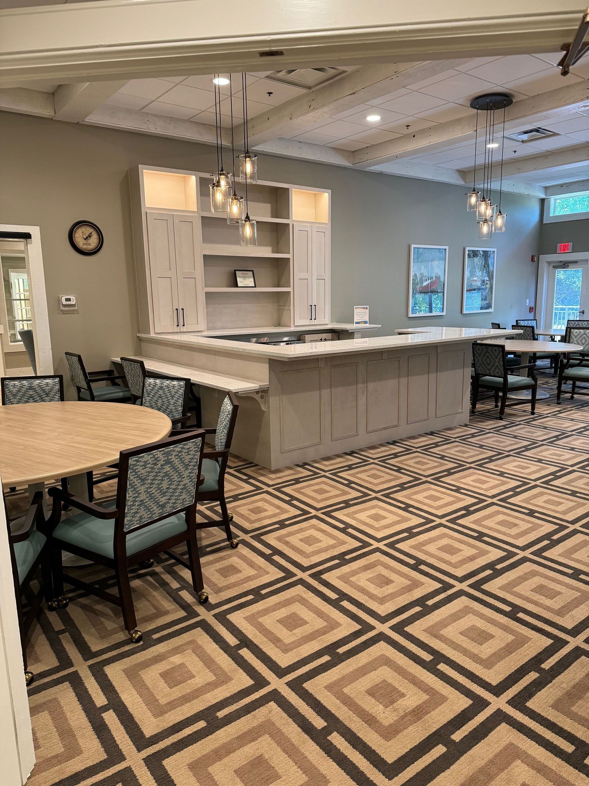 Commercial restaurant remodel and expansion - Tidepoint/After: Dining area with a large island, tables, chairs, and patterned carpet.