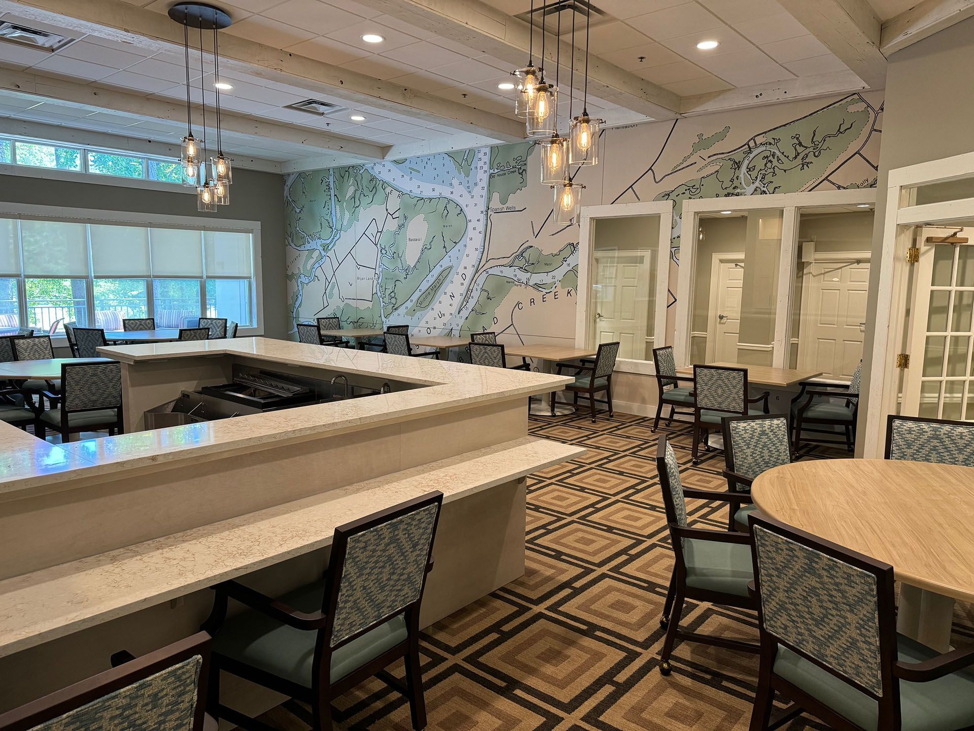 Commercial restaurant remodel and expansion - Tidepoint/After: Interior of a dining area with a bar, tables, chairs, and a map-like wall design.