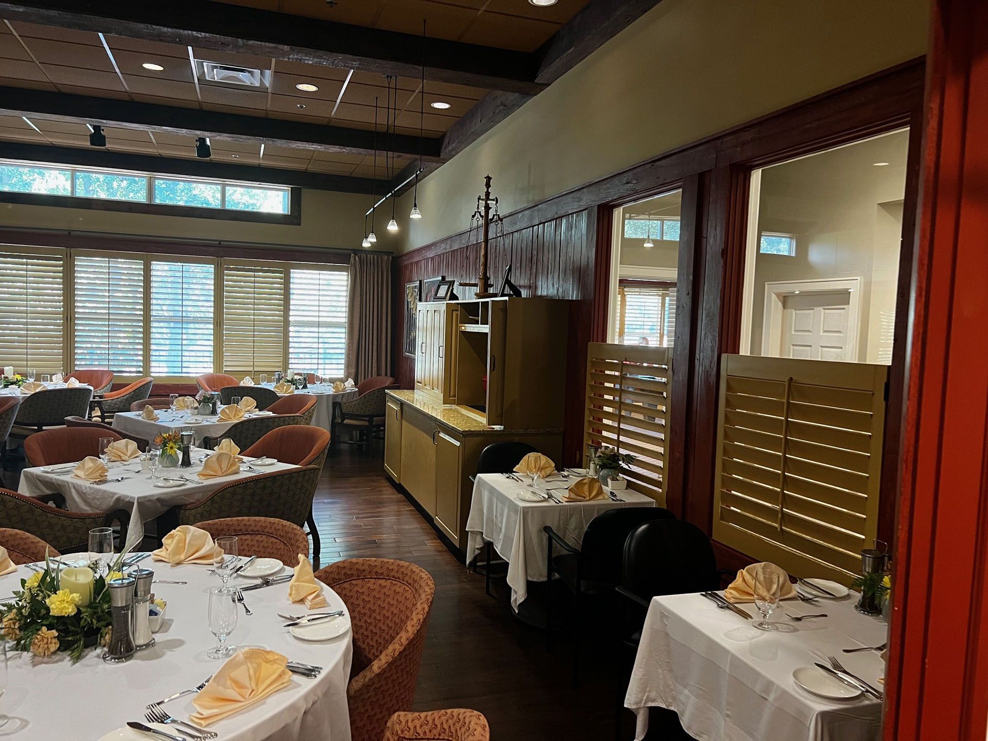 Commercial restaurant remodel and expansion - Tidepoint/Before: Restaurant dining room with tables set for service, featuring white tablecloths and beige chairs.