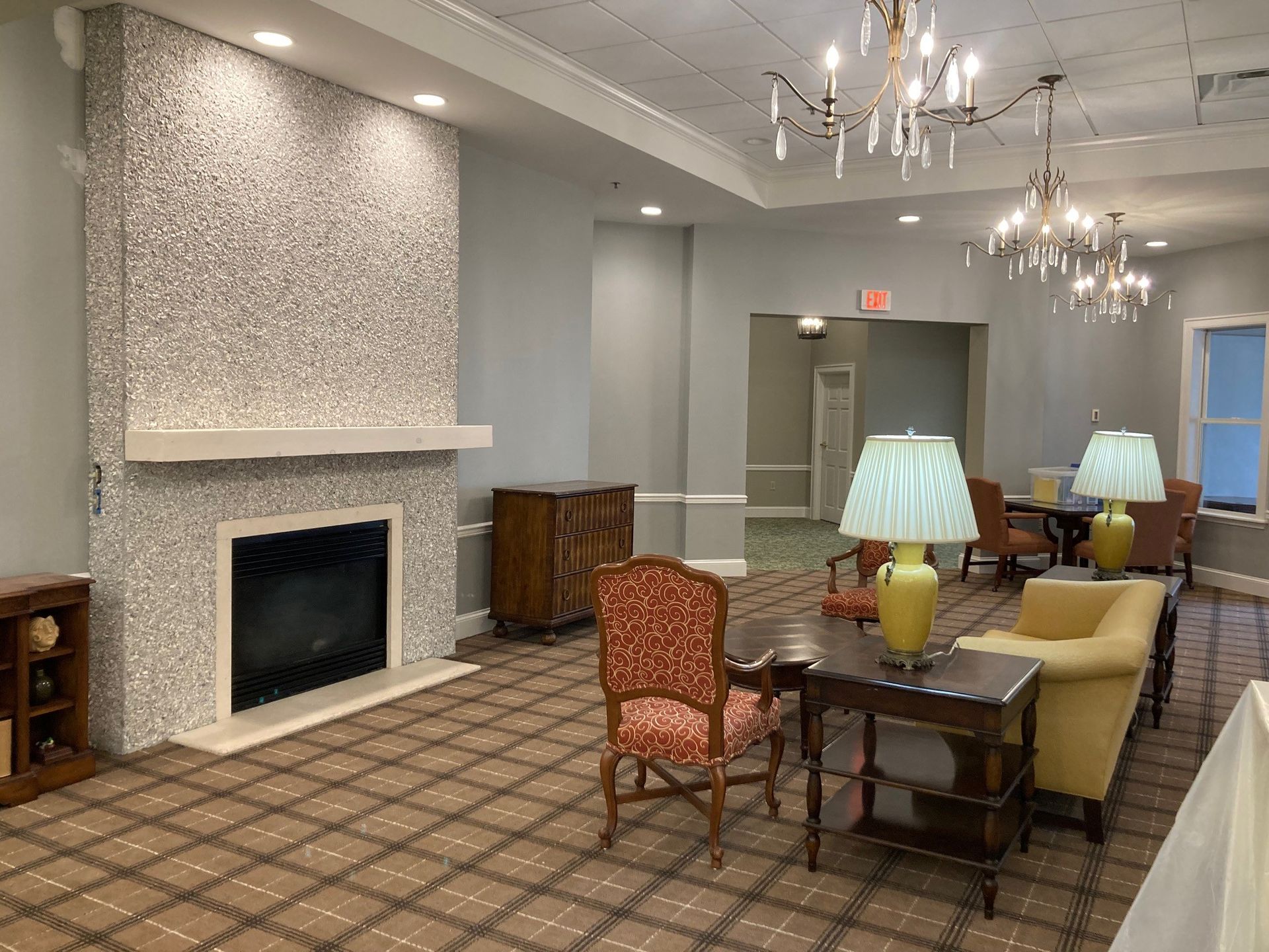 Lounge area with fireplace and seating. Fireplace with mosaic texture, antique furniture, and chandeliers.