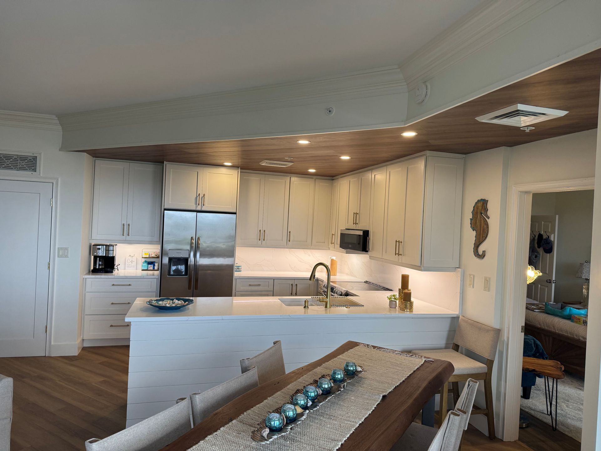 Kitchen with white cabinets, stainless steel appliances, and a wooden table.