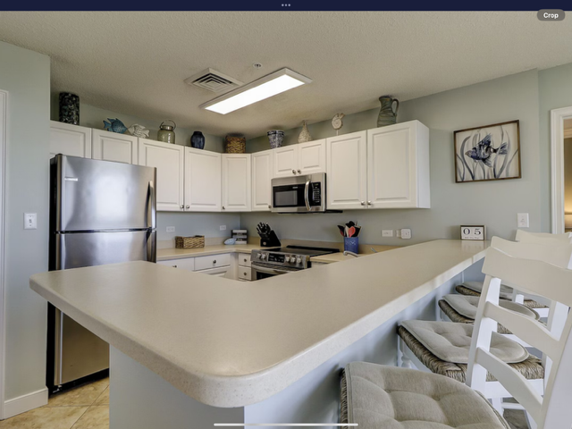 Kitchen with white cabinets, stainless steel appliances, and a breakfast bar with seating.