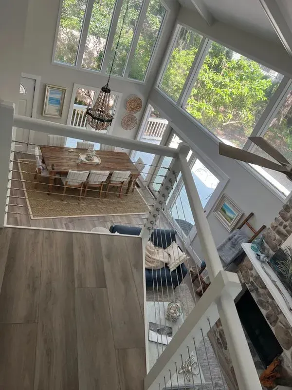 High-angle view of a bright, modern interior with a dining area, living room, and large windows.
