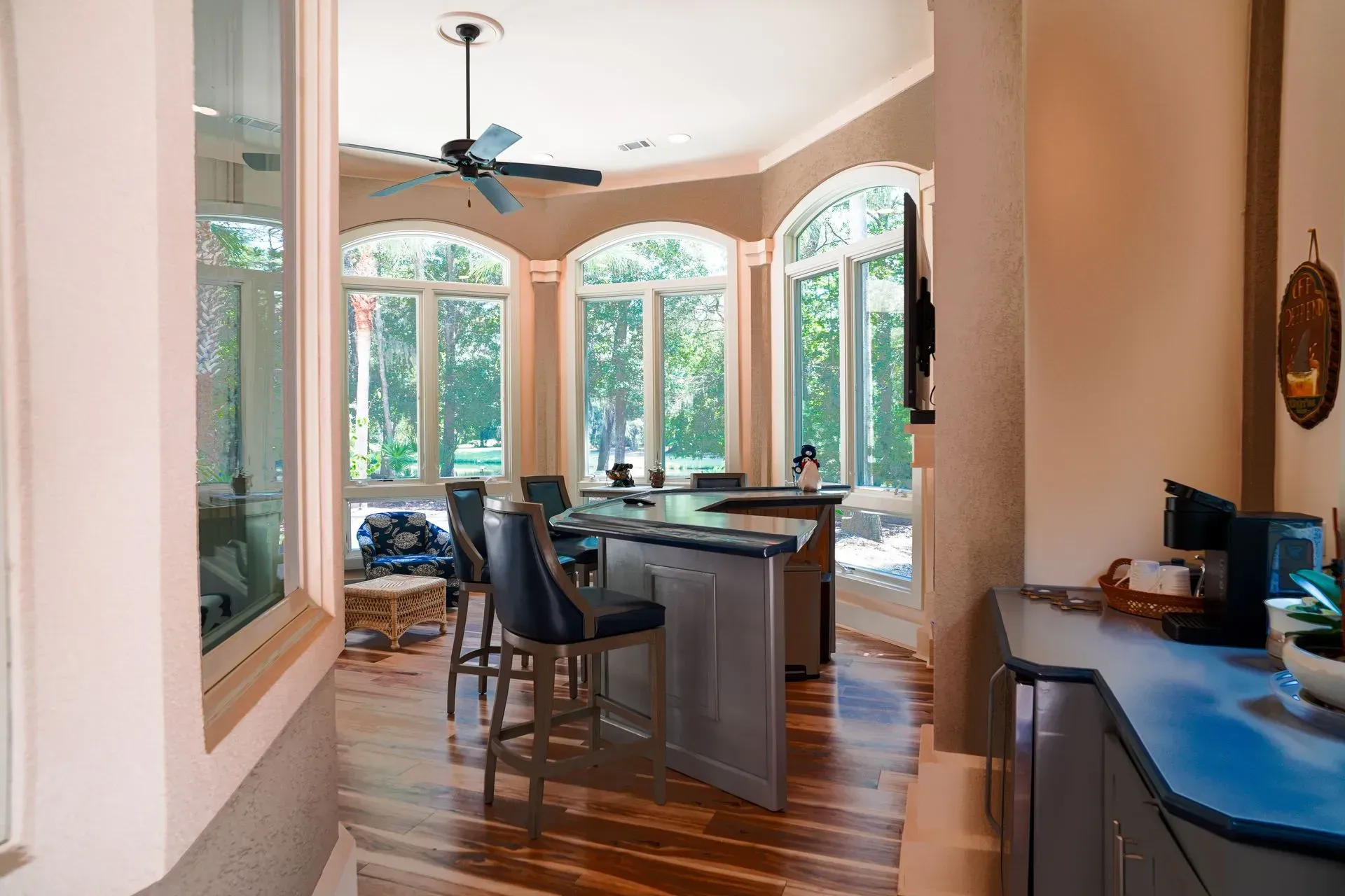 Kitchen with breakfast bar, arched windows, and hardwood floors.