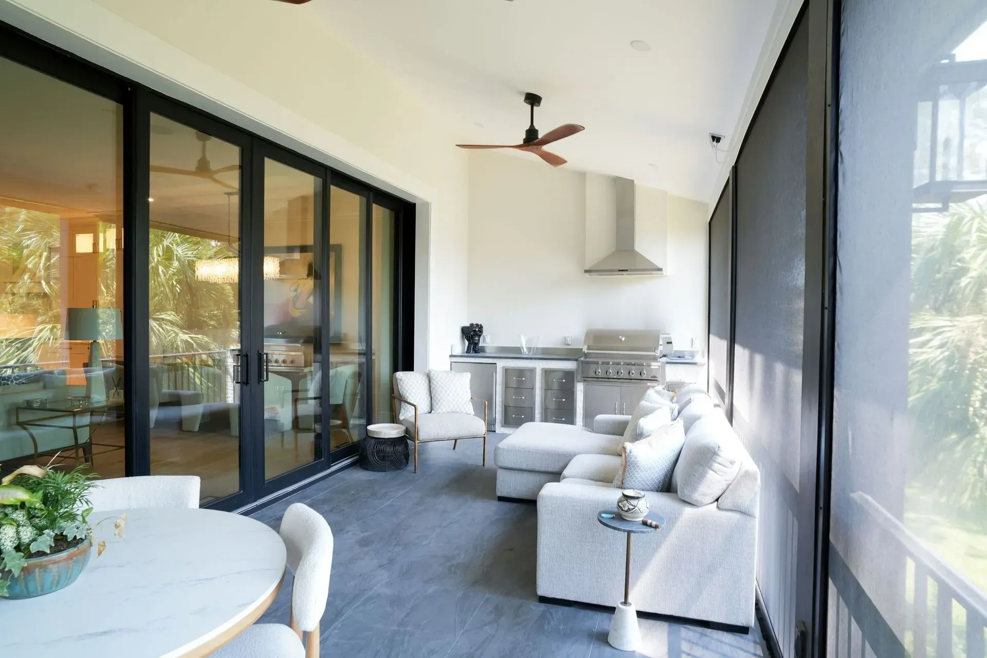 Covered outdoor patio with kitchen, seating, and large sliding doors.