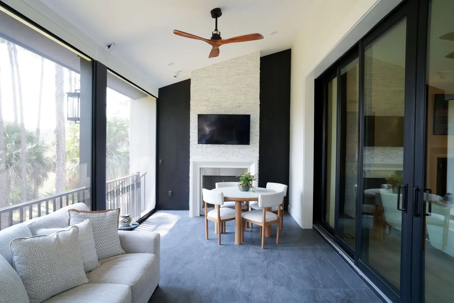 Covered patio with a seating area, fireplace, and sliding glass doors.
