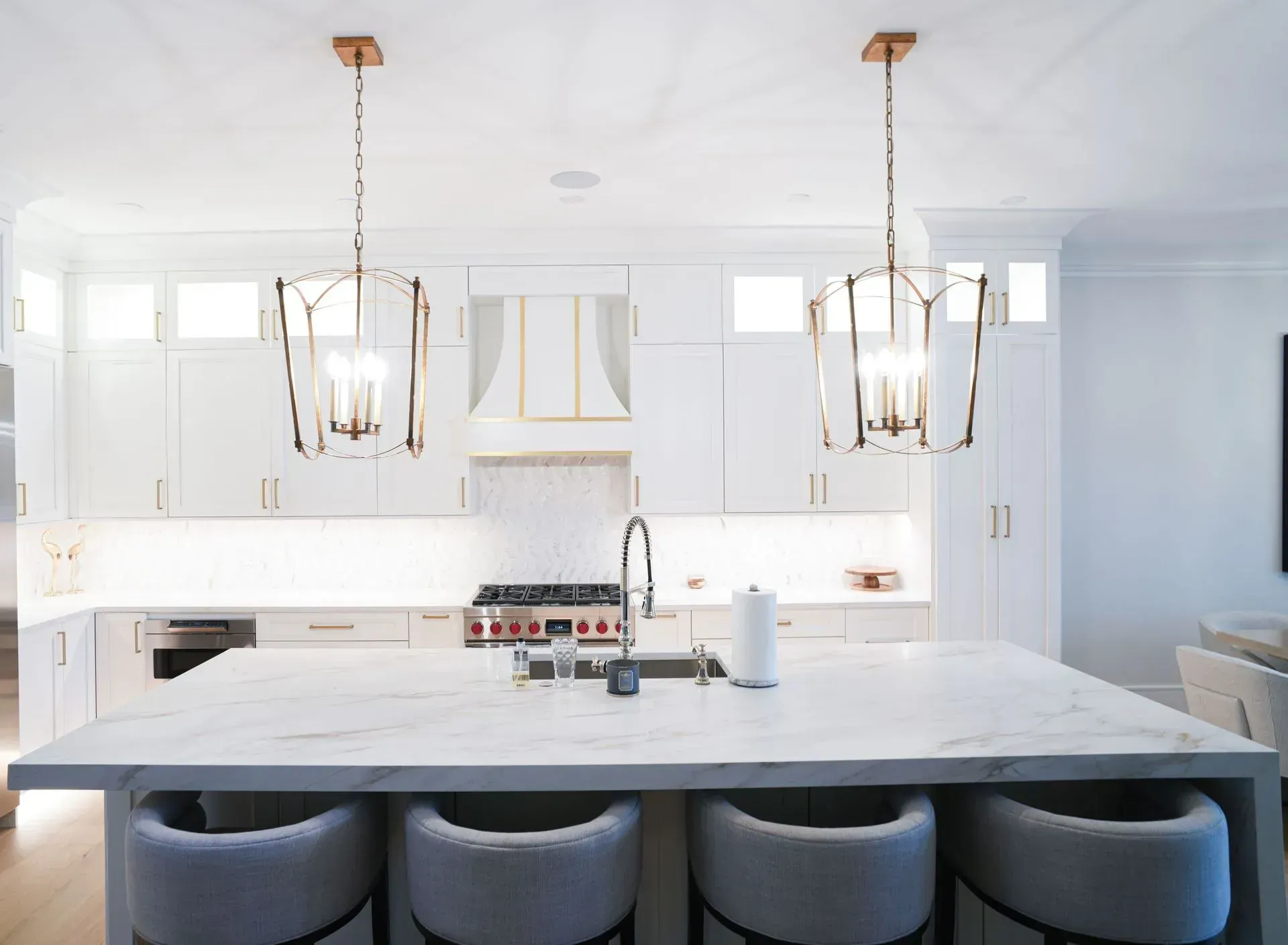 White modern kitchen with island and pendant lights.