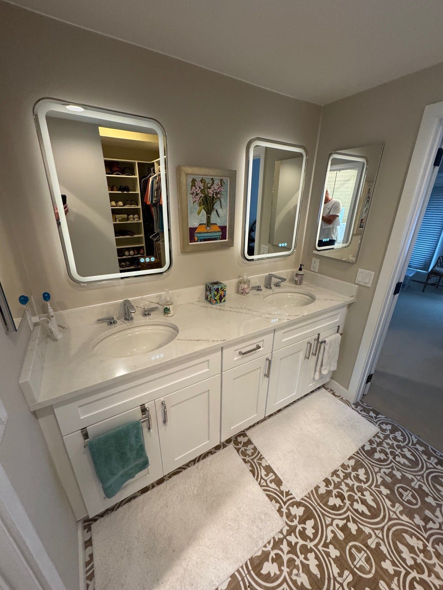 Shower stall with glass doors, white tiled walls, and pebble flooring. Stainless steel fixtures.