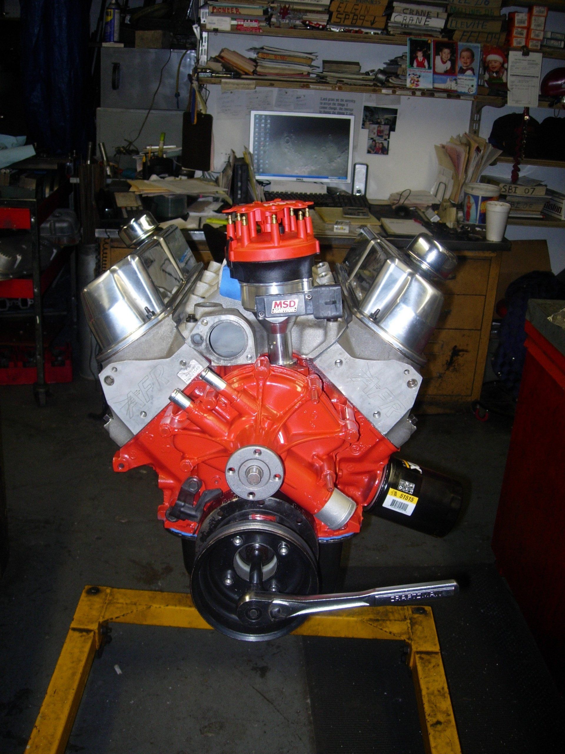 A red and silver engine is sitting on a yellow stand
