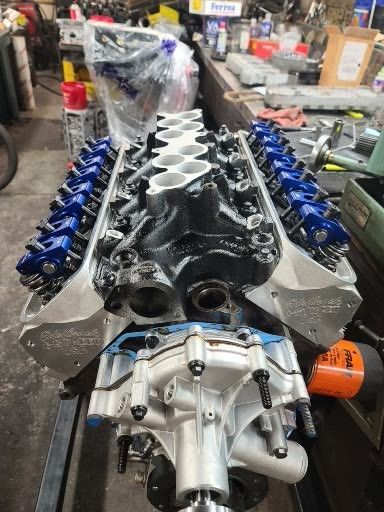 A large engine is sitting on a table in a garage.