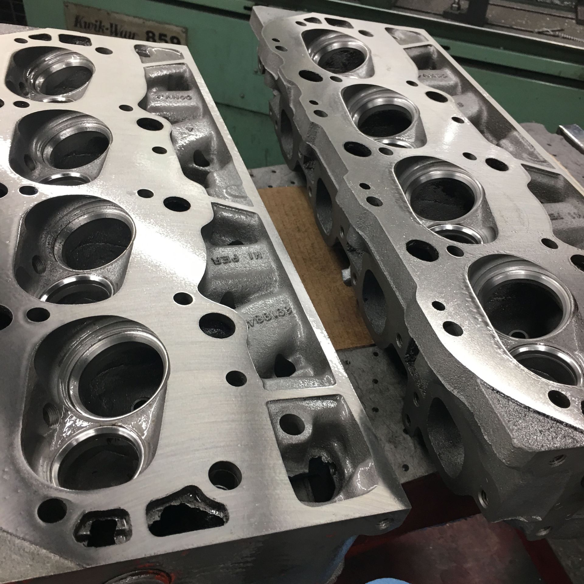 Two cylinder heads are sitting on top of each other on a table