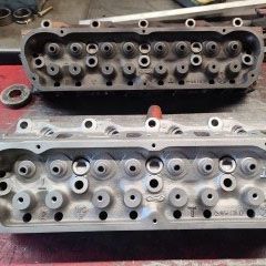 Two cylinder heads are sitting next to each other on a table.