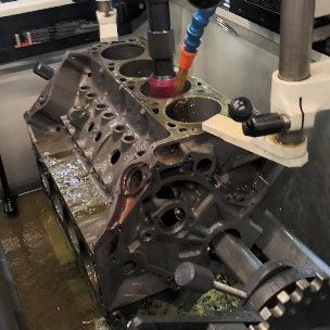 A machine is cutting a block of a car engine.