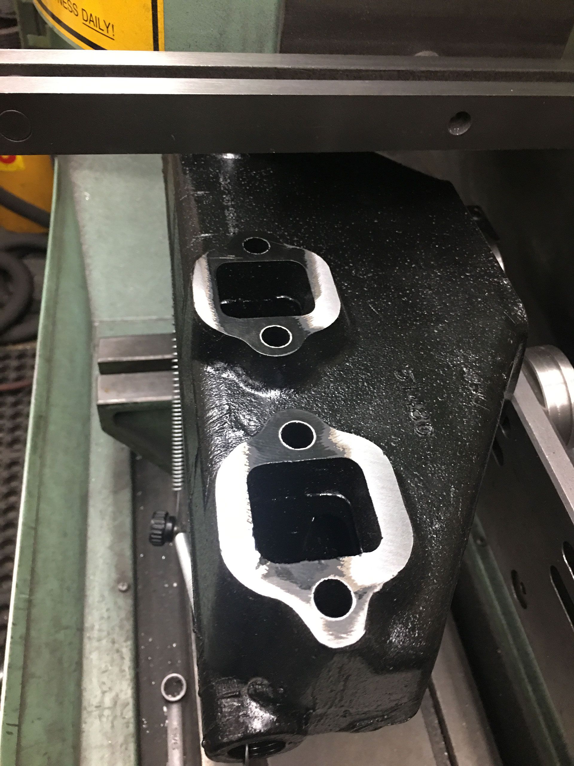 A black piece of metal is being worked on by a machine