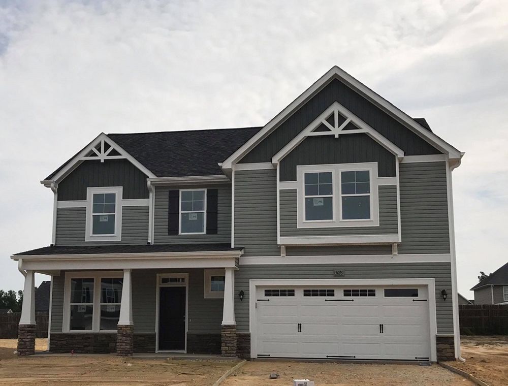 A large gray house with a white garage door
