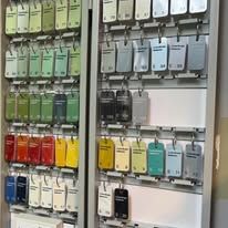 A display case filled with lots of different colored keys hanging on a wall.
