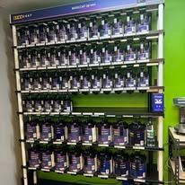 A shelf filled with lots of bottles of paint.