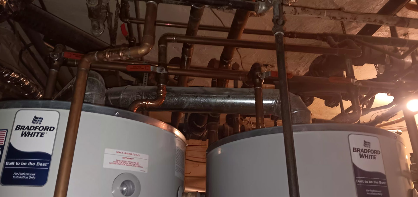 Two water heaters with copper piping.