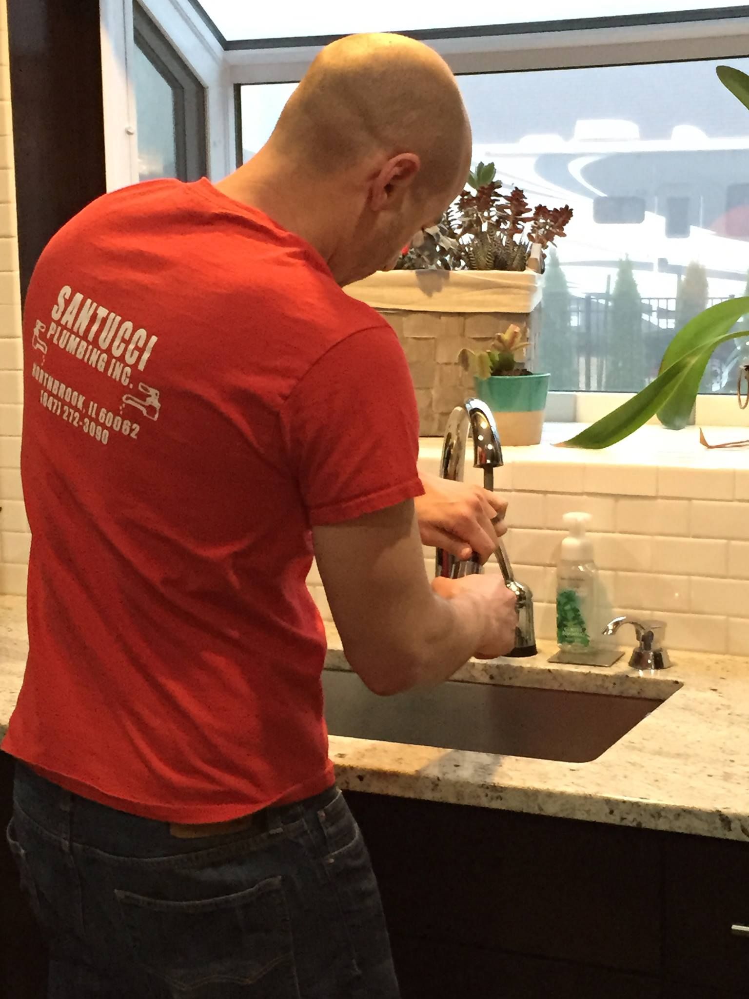 A man wearing a red shirt that says santos on it