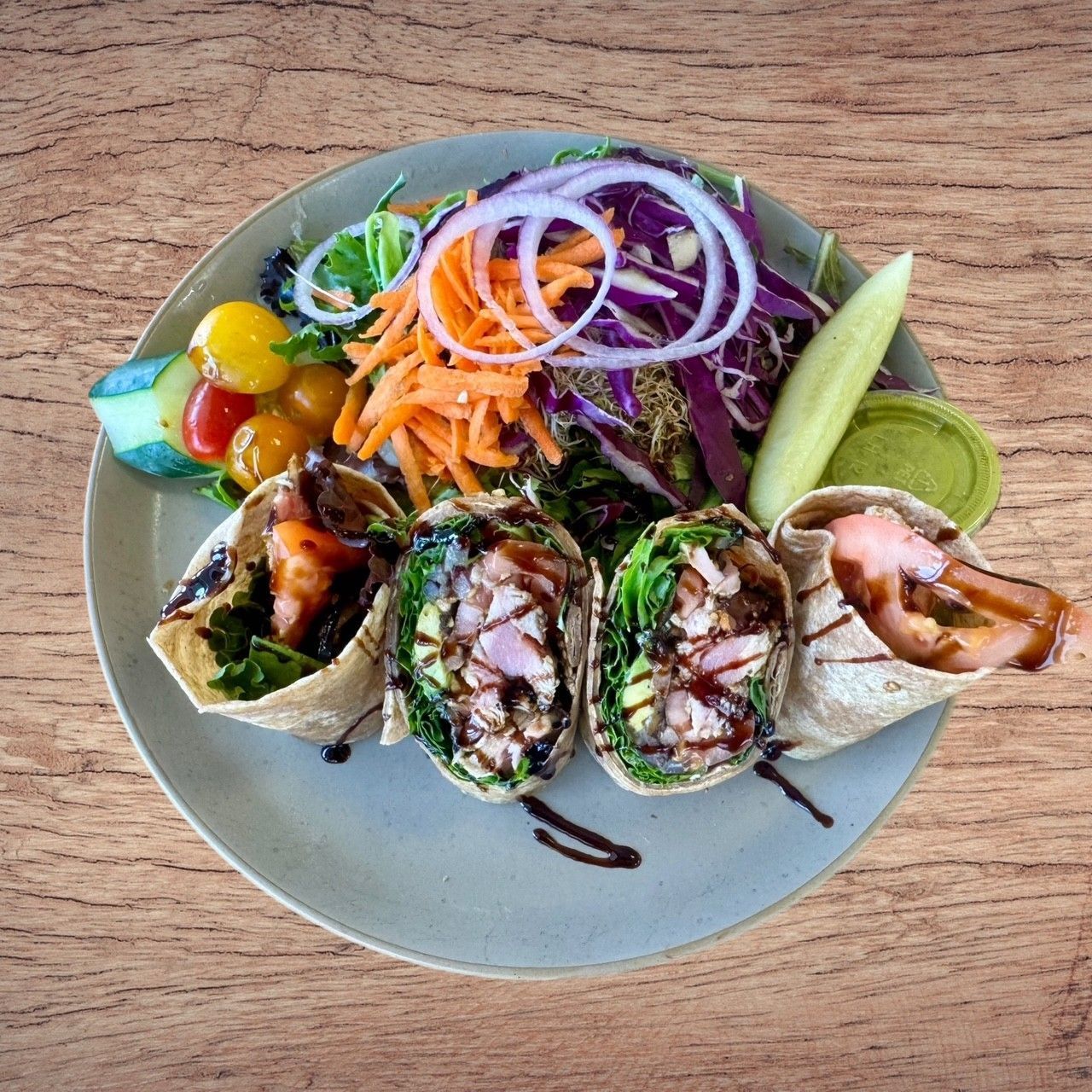 Plate with wraps and salad; wraps filled with fillings, and salad with vegetables.