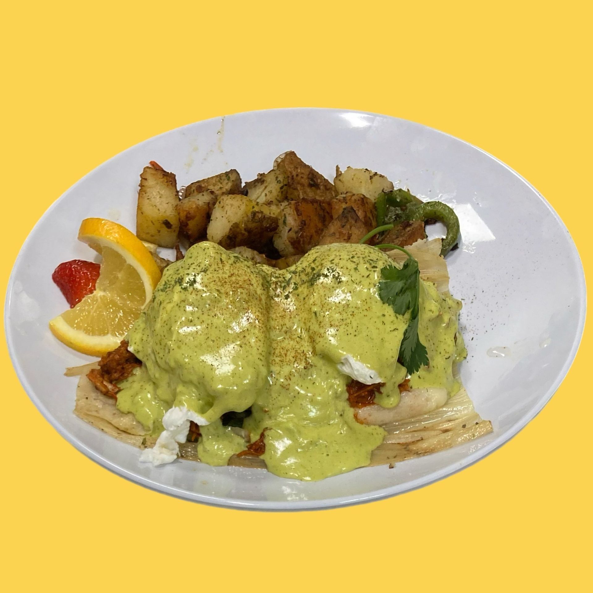 A plate of food with eggs benedict and potatoes on a yellow background