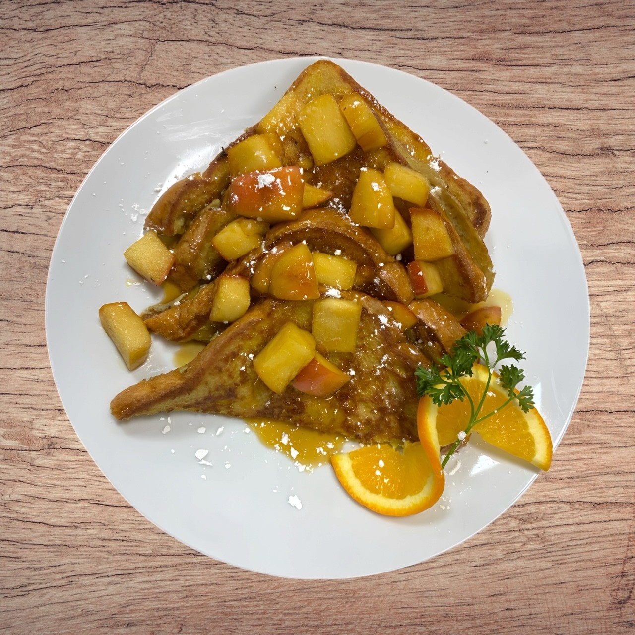 French toast with apples and oranges on a white plate