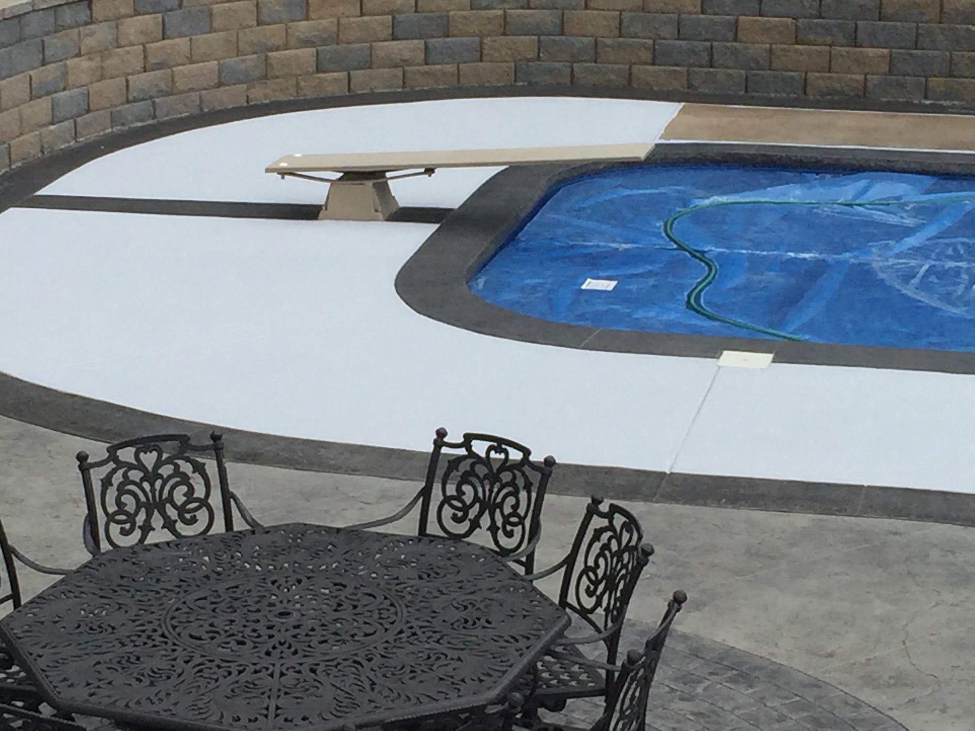A table and chairs in front of a swimming pool
