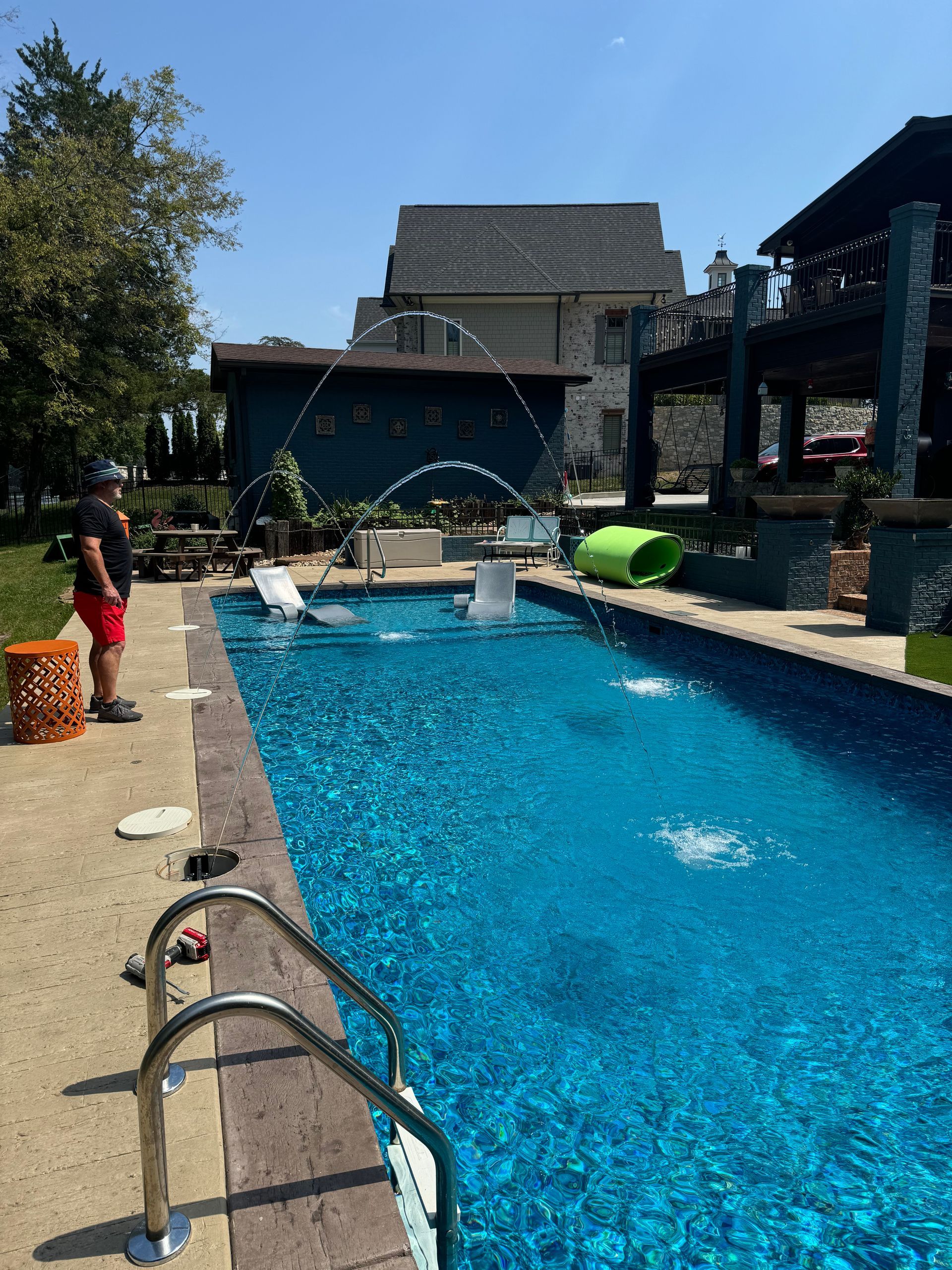 A large swimming pool with a fountain in the middle of it