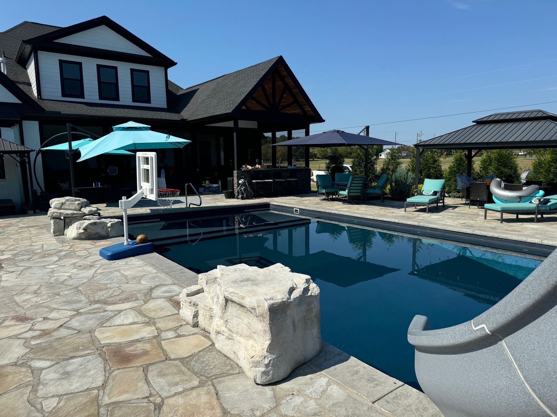 A large house with a swimming pool and a slide in front of it.