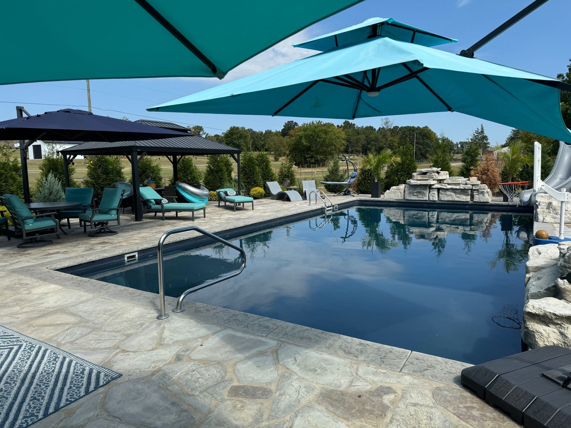 A large swimming pool with umbrellas and chairs around it