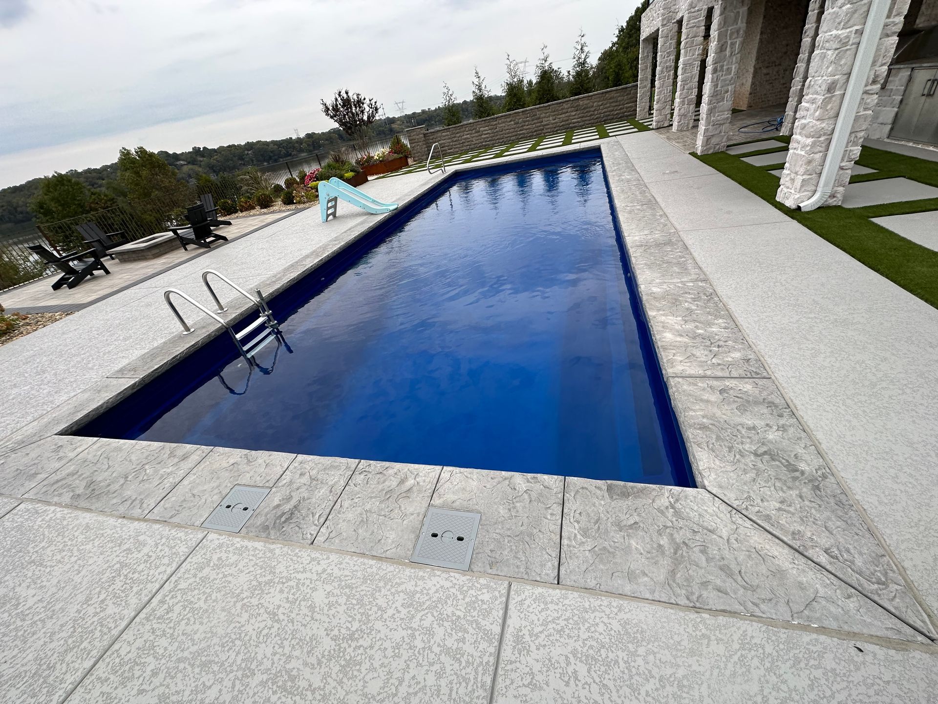 A large swimming pool with a slide in the background