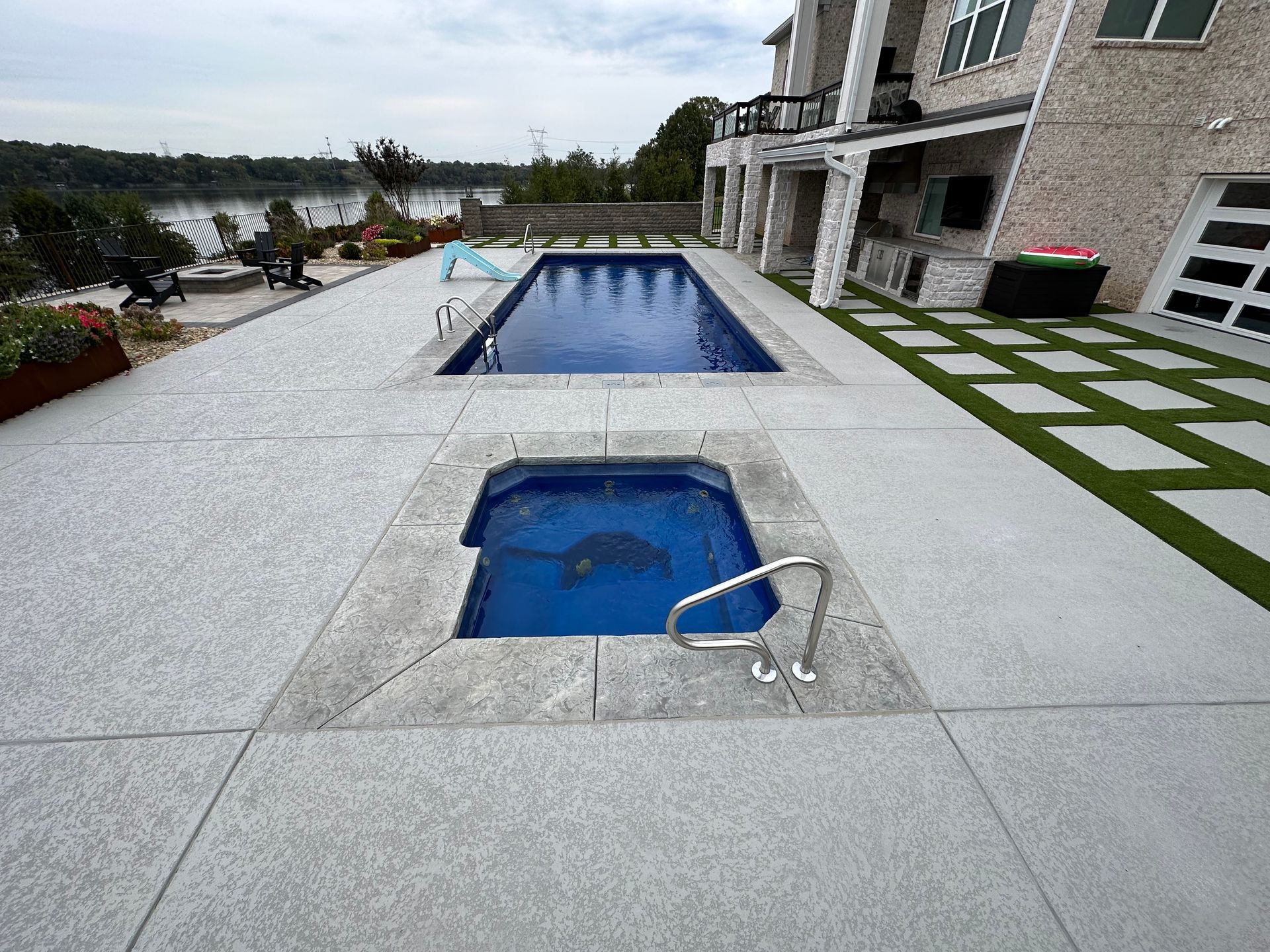There is a large swimming pool in the backyard of a house.