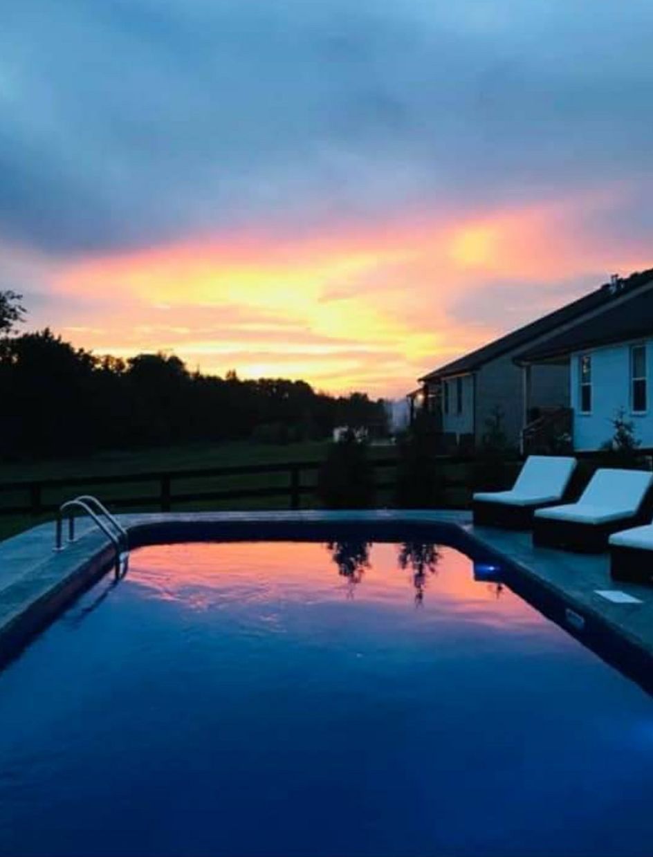 A swimming pool with a sunset in the background