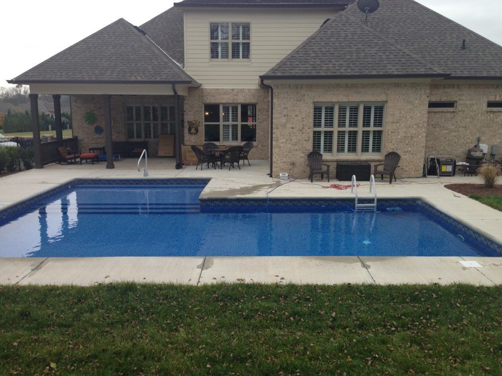 A large house with a large swimming pool in front of it