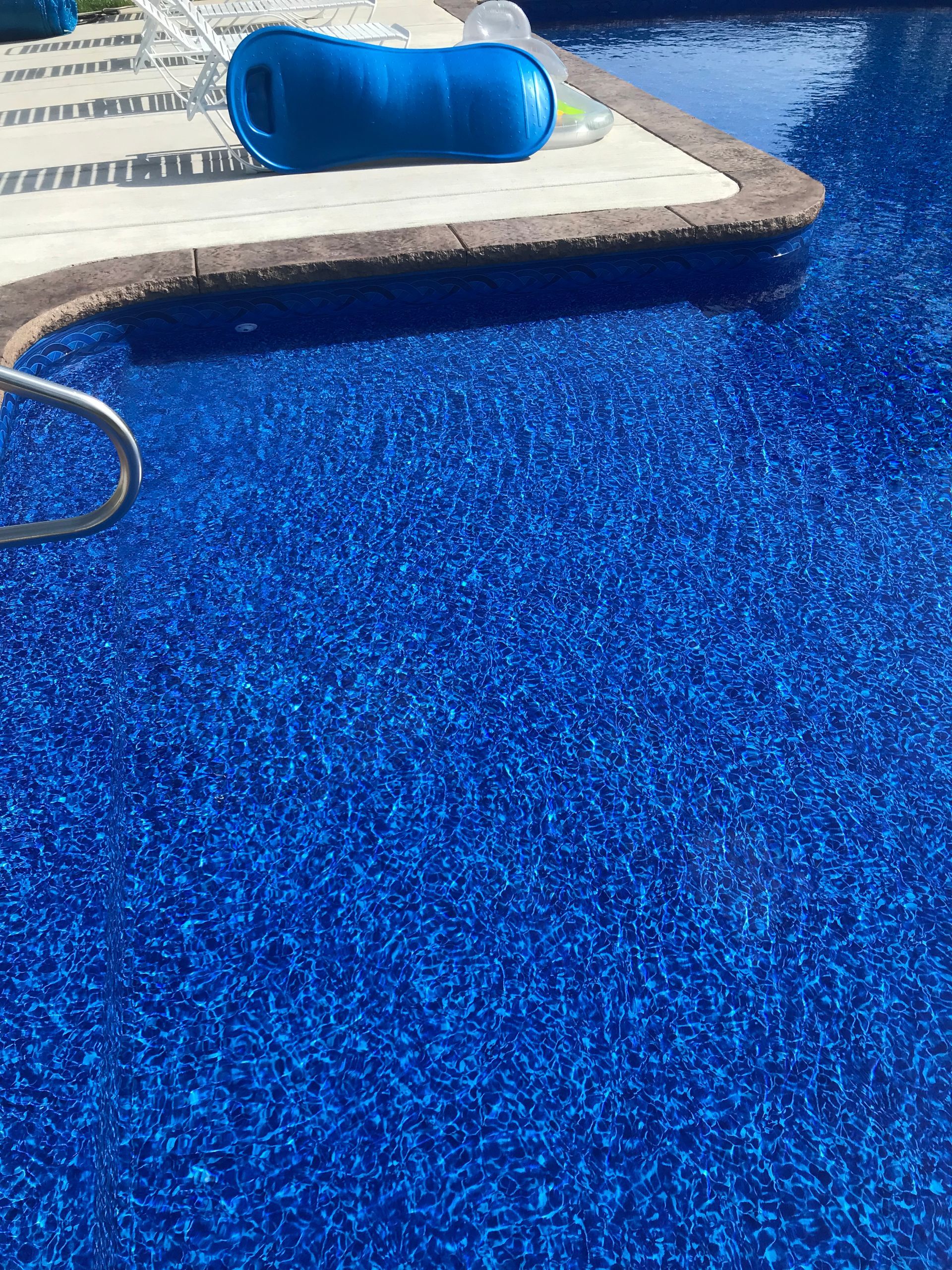 A blue swimming pool with a blue float in it.