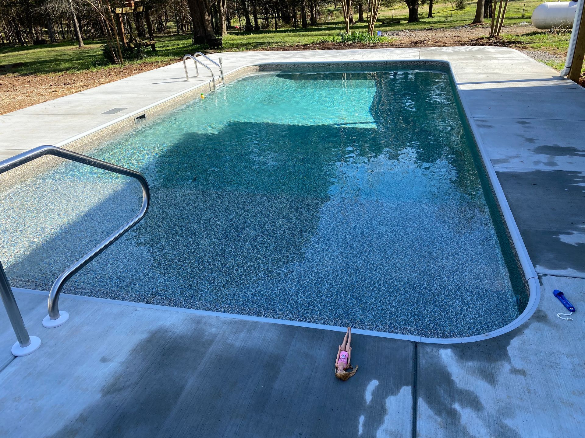 A large swimming pool with a pink bathing suit on the side of it.