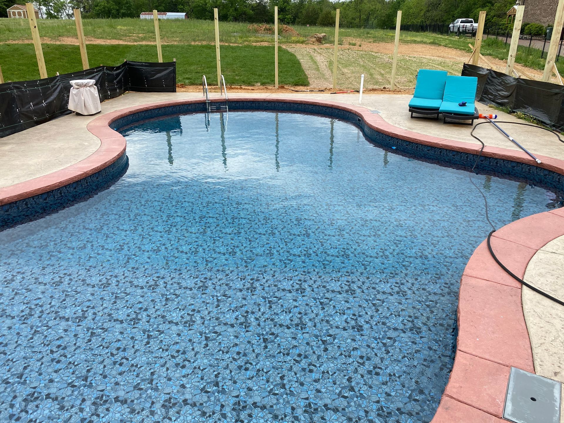 A large swimming pool is being built in a backyard.