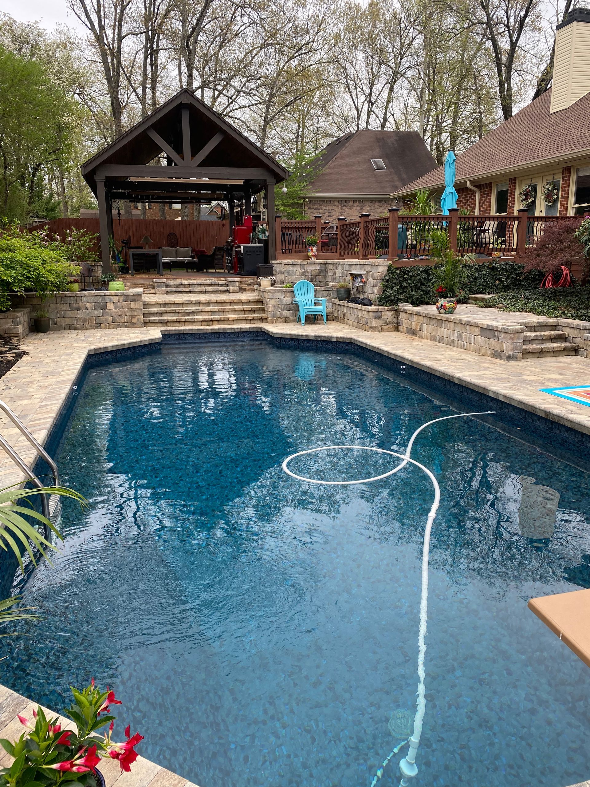 There is a large swimming pool in the backyard of a house.