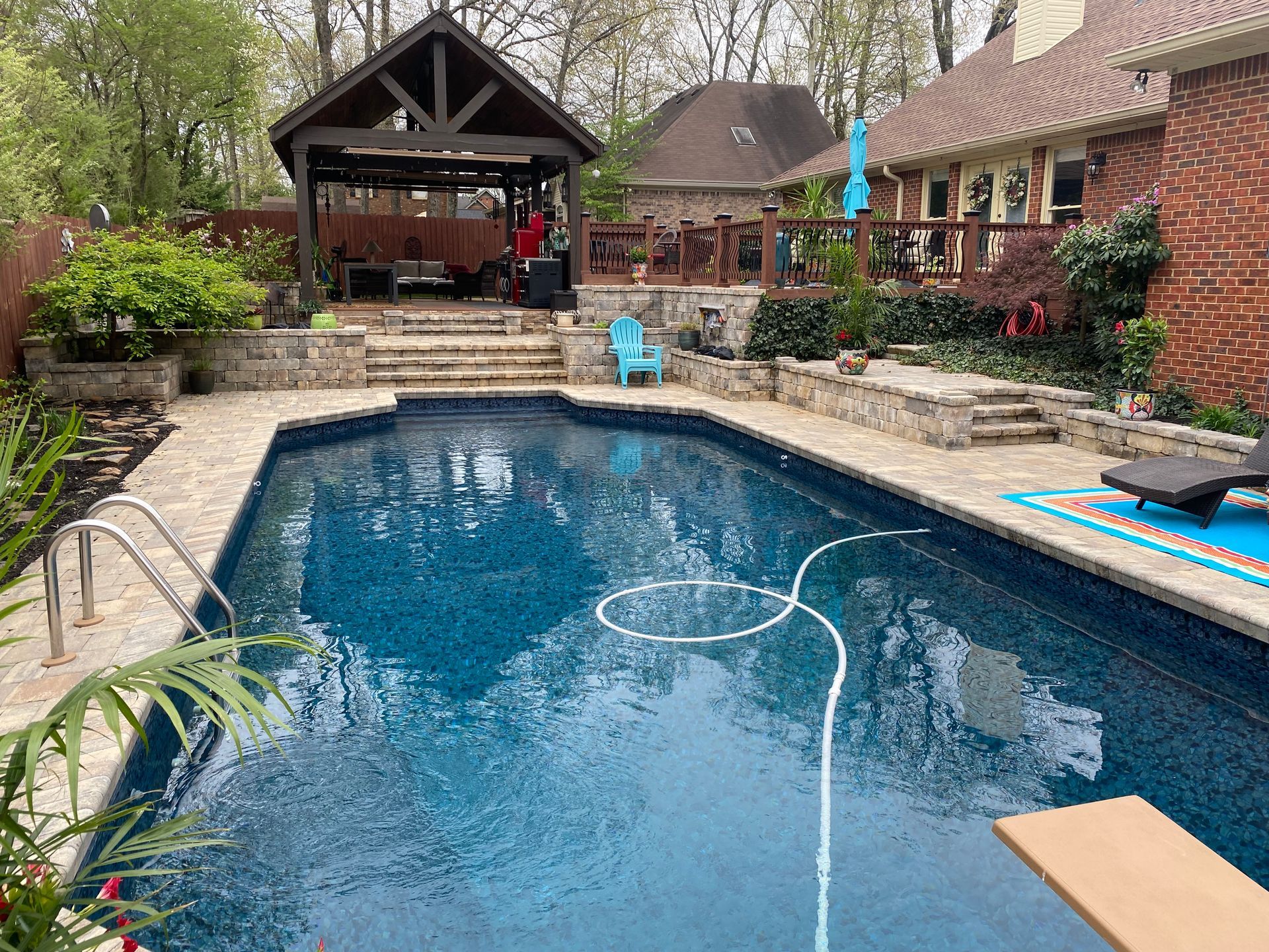 There is a large swimming pool in the backyard of a house.