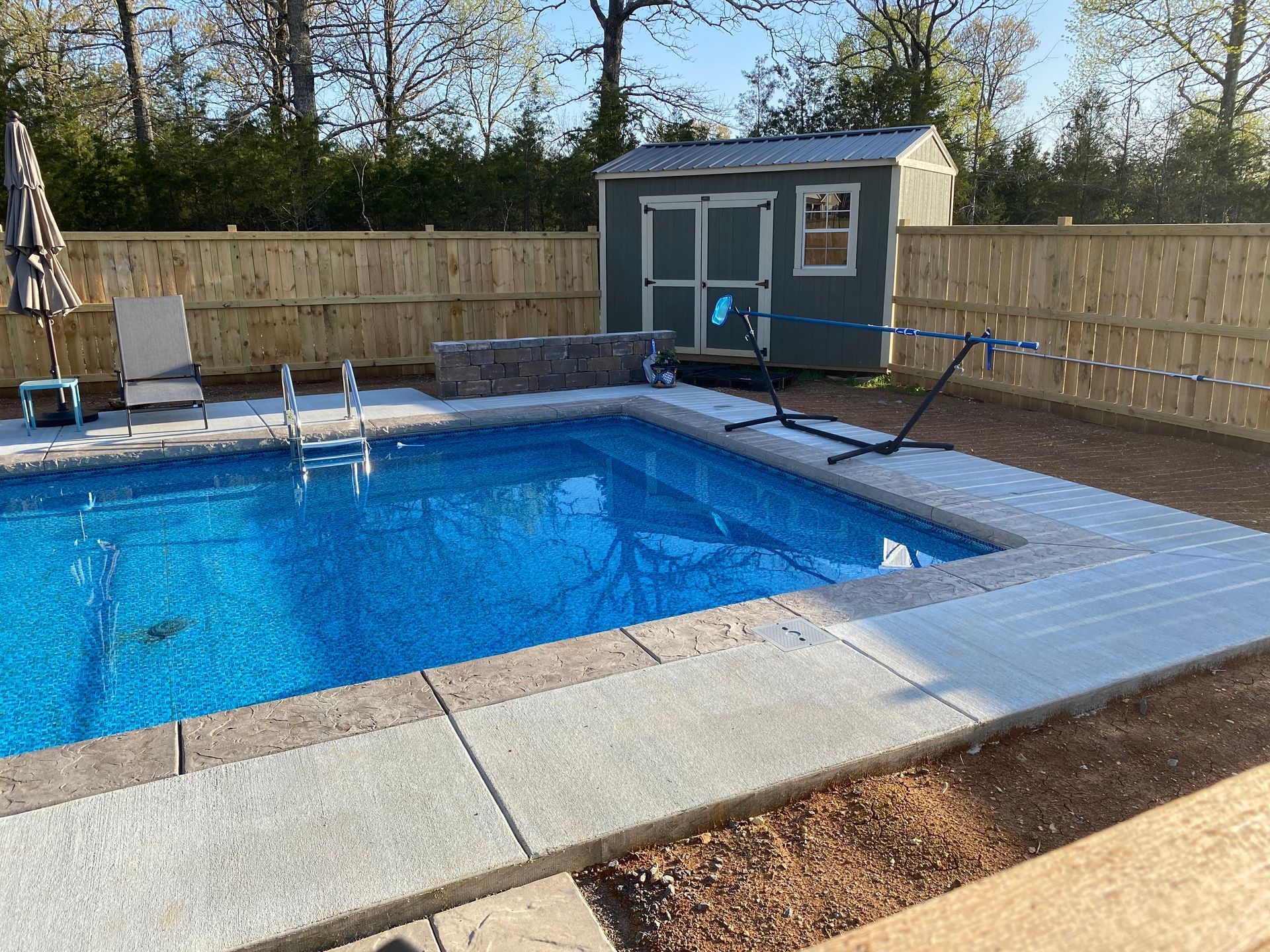 A large swimming pool with a shed in the background