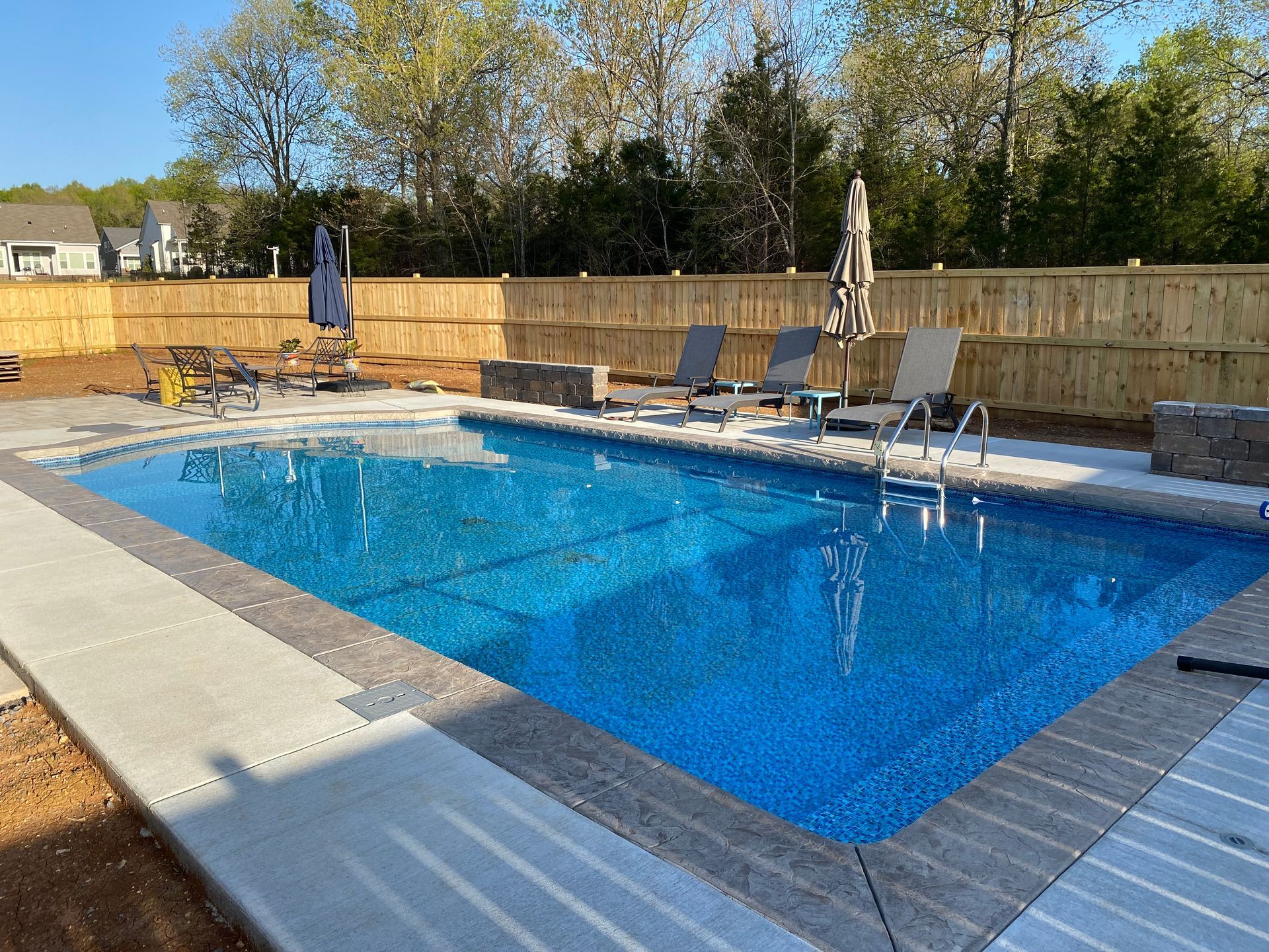 A large swimming pool with chairs and umbrellas around it