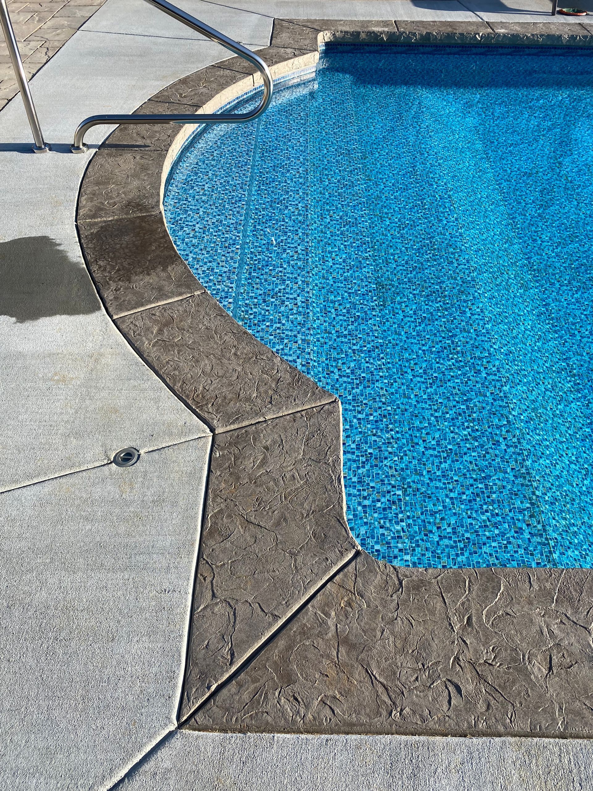 A close up of a swimming pool with a concrete border.
