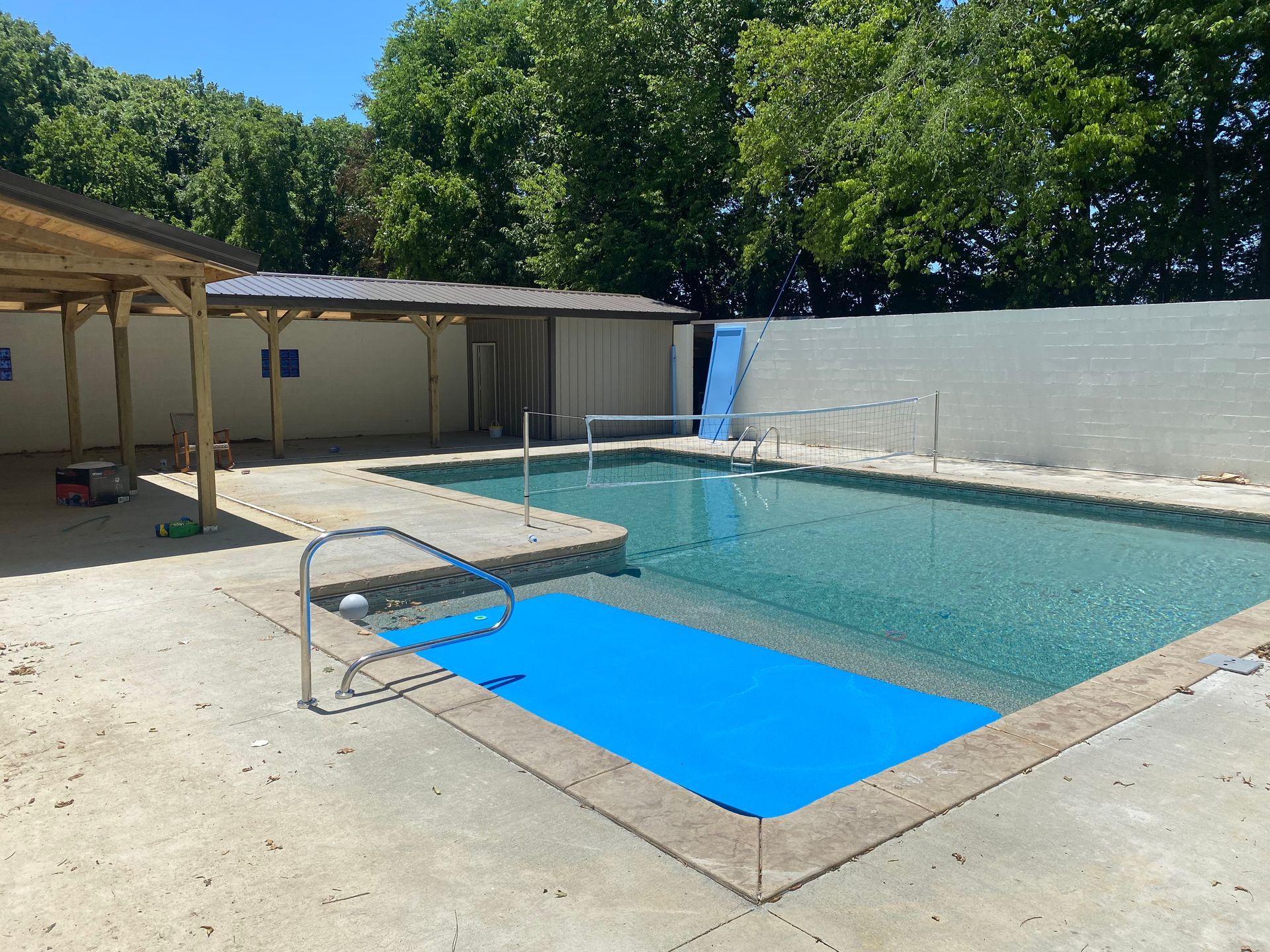 A large swimming pool with a blue mat on the edge