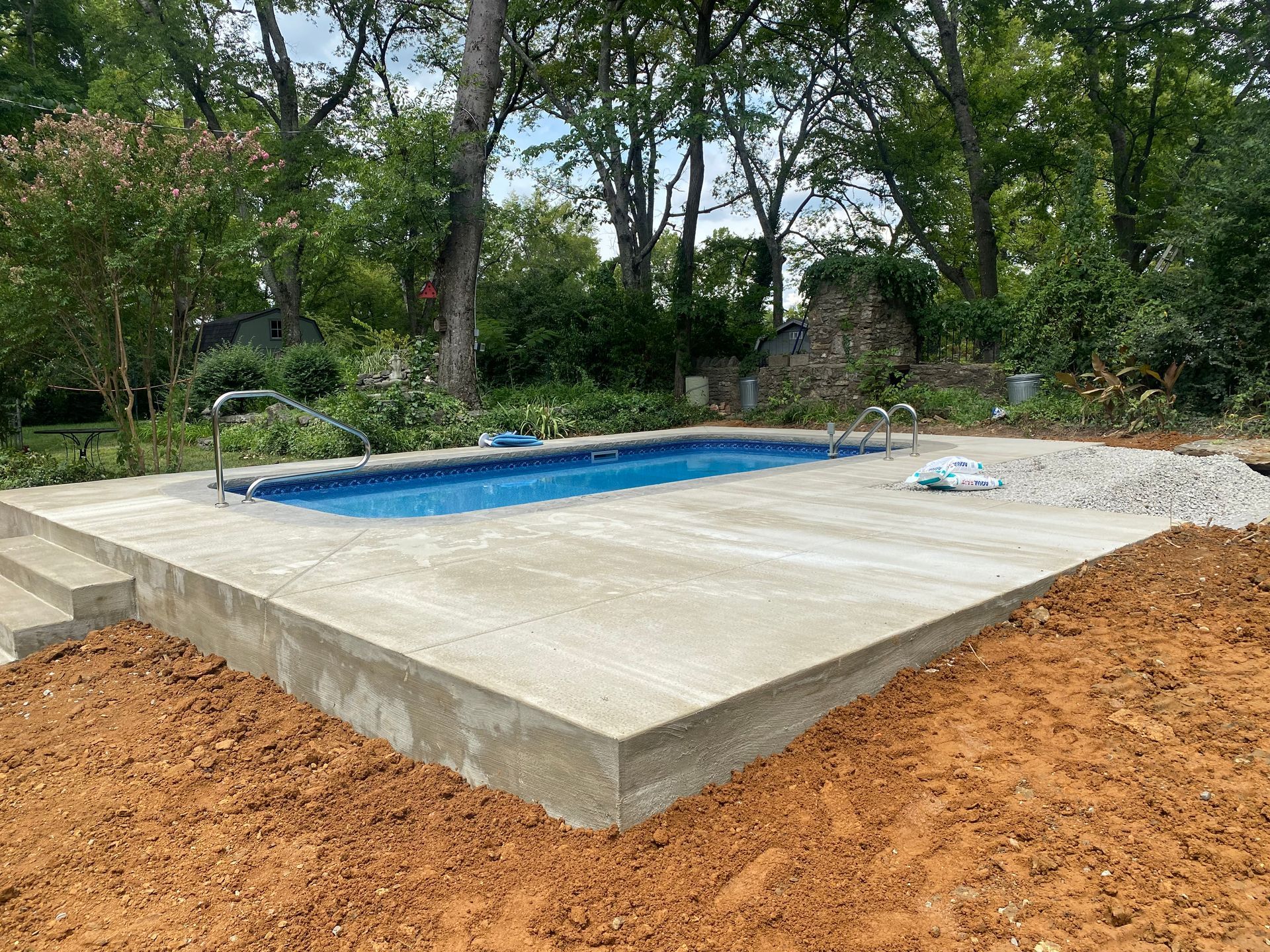 A swimming pool is being built in the backyard of a house.