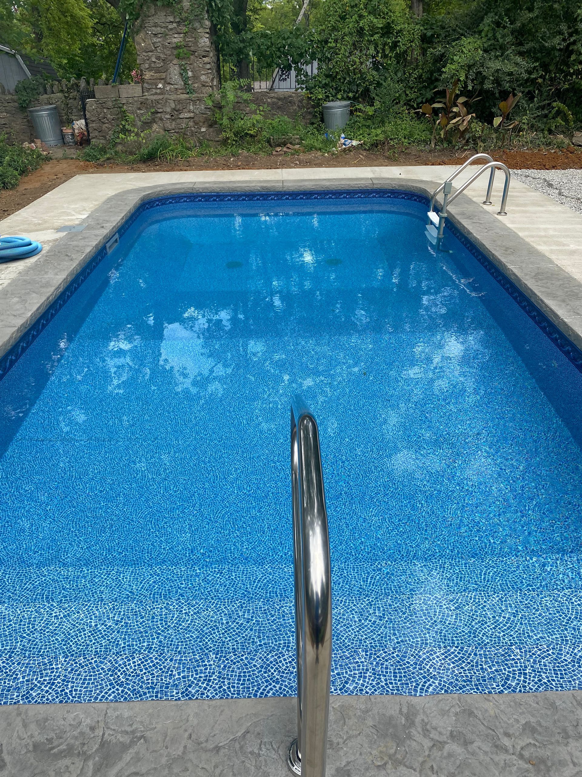A large swimming pool with a ladder leading to it.